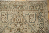 Time-softened pile texture of the distressed Karaja rug with geometric blossoms in beige and silver.