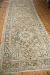 Distressed Karaja rug with hand-knotted geometric patterns and border in beige and muted green.