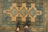Mostly even wear across the knot heads of a distressed vintage Senneh rug in dusty blue and cream tones.