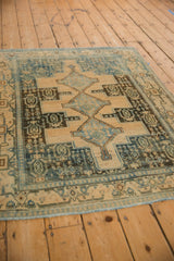 Worn texture and dusty blue geometric pattern on a distressed Senneh rug viewed from a high angle.