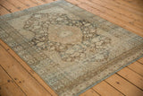Angled view of a distressed Persian Mahal rug showing its low-pile texture and neutral palette.