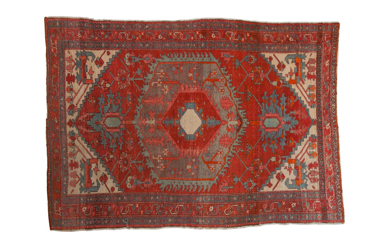 Antique Northwest Persian rug with concentric hexagonal medallions in brick red, sky blue, and faded ivory.