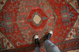The low pile and geometric detail of an antique Persian rug's hexagonal center medallion.