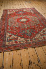 Antique Northwest Persian rug from an angled perspective, displaying its geometric form and time-softened colors.