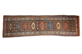 Vintage Kurdish runner rug with a single column of octagonal guls in red, blue, and ivory.