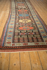 Angled view of a vintage Kurdish runner's repeating octagonal medallions and geometric borders.