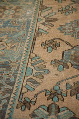Detail of the worn, hand-knotted pile showing the serrated leaf border in cream and turquoise.