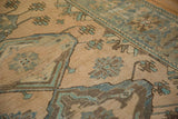 Knot heads and foundation visible through the low pile of a distressed Malayer rug with floral motifs.