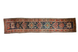 Vintage Persian runner with a central column of Karaja medallions in red and green on a navy blue field.