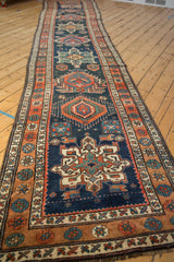 The full length of a vintage Persian runner displaying its column of geometric Karaja-style medallions.