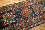 Angled view of a vintage Persian runner, showing the repeating Karaja-style center medallions.