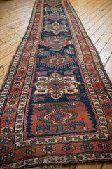 Angled perspective down the length of a vintage Persian runner showing its repeating medallions.
