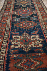 A view down the length of a vintage Persian runner showing its repeating geometric Karaja medallions.