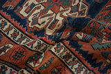 A close-up of the hand-knotted wool pile showing Karaja stylization in navy, red, and ivory.