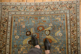 Evenly worn pile of a distressed Malayer rug with floral bouquets on a slate blue field.