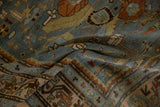 Close-up on the soft, low-pile texture and serpent border of a vintage distressed Malayer rug.