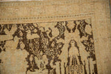 Time-softened pile on a distressed Persian rug corner with a chocolate brown human-like lantern design.