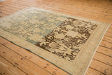 Angled view of a distressed Bijar rug showing a bold dye lot change in its field.