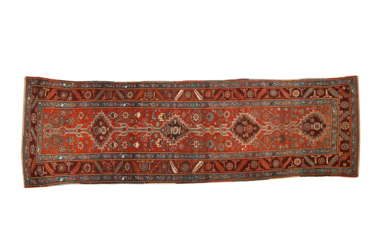 Antique Northwest Persian rug runner with interconnected medallions in rich brick red and contrasting sapphire blue.