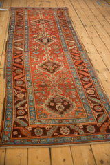 Angled view of an antique Northwest Persian runner emphasizing its long profile and stepped medallions.
