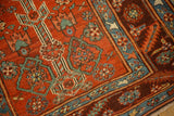 Close-up of stepped contour medallions and floral motifs in red, blue, and jade on an antique Persian runner.