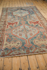 Low angle view showcasing the distressed texture and full length of a vintage Persian Malayer carpet.