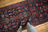 Vintage Mehreban runner featuring intricate blossom medallions, boteh, and colorful creatures on a navy blue ground.