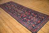 Vintage Persian Mehreban runner with a dense navy field, vibrant floral motifs, and banded red border.