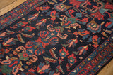 Vintage Persian Mehreban runner's navy field with colorful blossoms and serrated motifs.