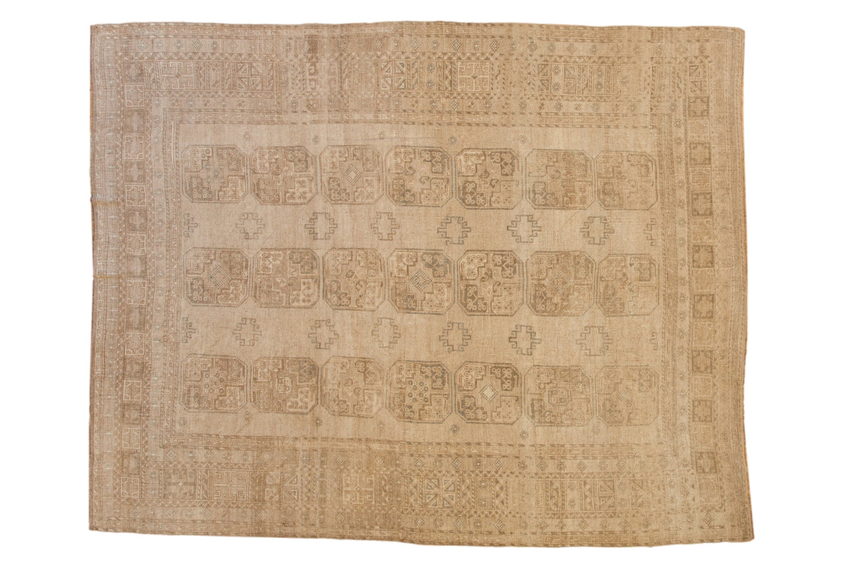 Vintage distressed Ersari carpet with geometric elephant footprint guls in a neutral palette of sand and antique ivory.