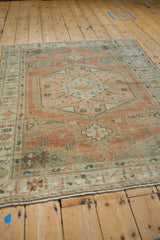 Angled view of the distressed Persian Veece rug's full geometric design in rose and silver.