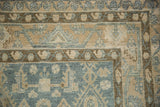 Detail of the evenly worn pile on a vintage Hamadan rug, showing the corner's vine border.