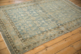 Angled view of a vintage Hamadan rug showing the time-softened texture and border detail.