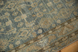 Detail of the meandering vine border and the distressed rug's evenly worn, low pile.