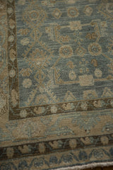 Detail of the meandering vine main border and worn, low pile of a distressed Persian Hamadan rug.