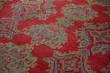 Hand-knotted pile texture of a vintage Oushak carpet with red, blue, and gold geometric motifs.