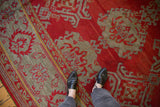 Evenly worn, hand-knotted pile showing palmette designs in red and slate blue on an antique Oushak.