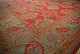 Corner of an antique Turkish Oushak showing the palmette vine border in dusty slate blue and red field.