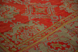 Textured low pile of an antique Oushak with red and slate blue hook-and-latch medallions.