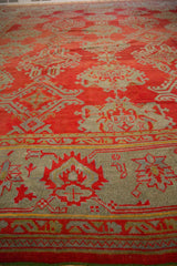 Main border of an antique Oushak with palmette vine and low, evenly worn red and slate pile.
