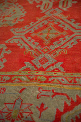 The hand-knotted texture and even wear of a red and slate blue antique Oushak's pile.