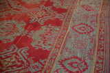 Detail of the red field and slate blue palmette vine border on an antique Oushak carpet.