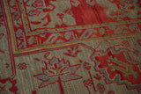 Even wear on the hand-knotted pile of an antique Oushak in red and oxidized silver tones.