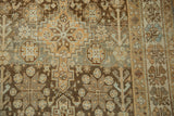 The worn pile of a vintage Afshar rug showing starburst motifs in coffee brown and slate blue.