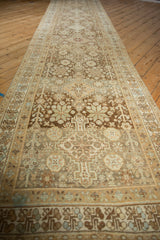 Angled view down the length of a distressed Afshar runner with earthy-toned geometric medallions.