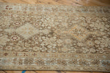 Geometric starburst and pomegranate motifs on the low pile of a distressed Persian Afshar runner.