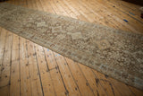 Vintage Afshar runner laid out diagonally, showing its distressed, repeating medallions in muted brown tones.