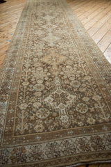 Angled view showing the full length of a distressed Afshar runner with repeating geometric medallions.
