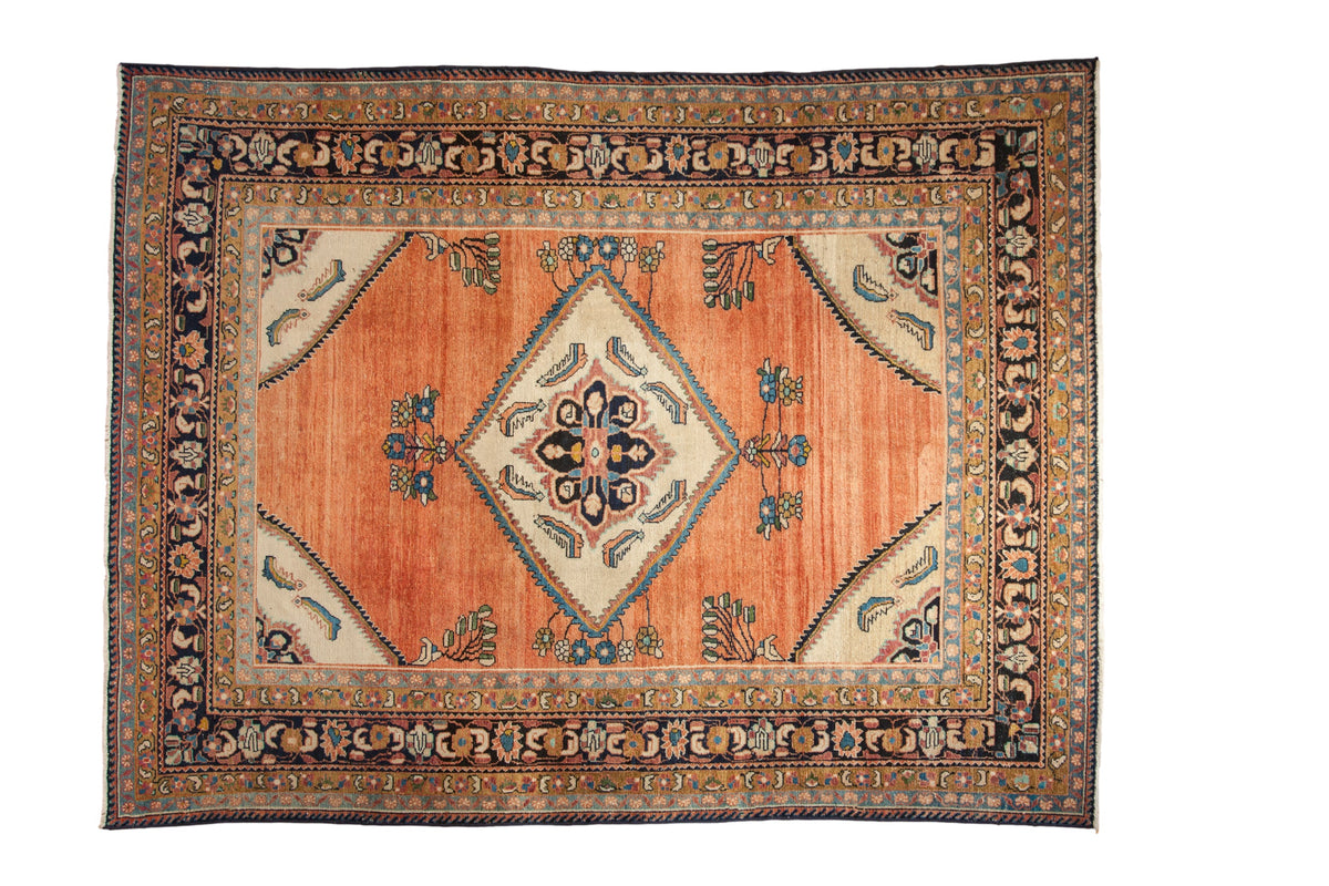 Vintage Lilihan carpet with a central diamond medallion, an abrashed copper-rose field, and intricate navy borders.
