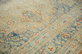 Low-pile texture of a vintage Meshed carpet showing dusty blue and rust boteh and floral details.